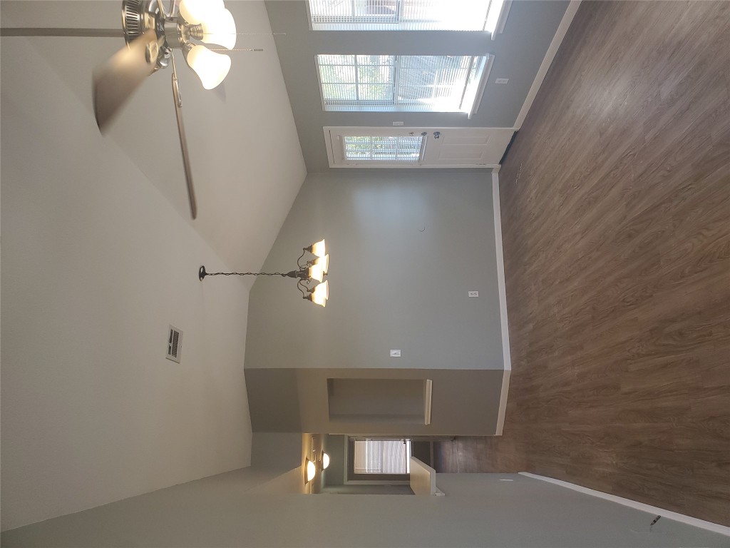 2221 Creekside Lane, Unit B Georgetown, TX 78626 - Photo 12 of 33 Unfurnished dining area with dark wood finished floors, a ceiling fan, vaulted ceiling, and a chandelier