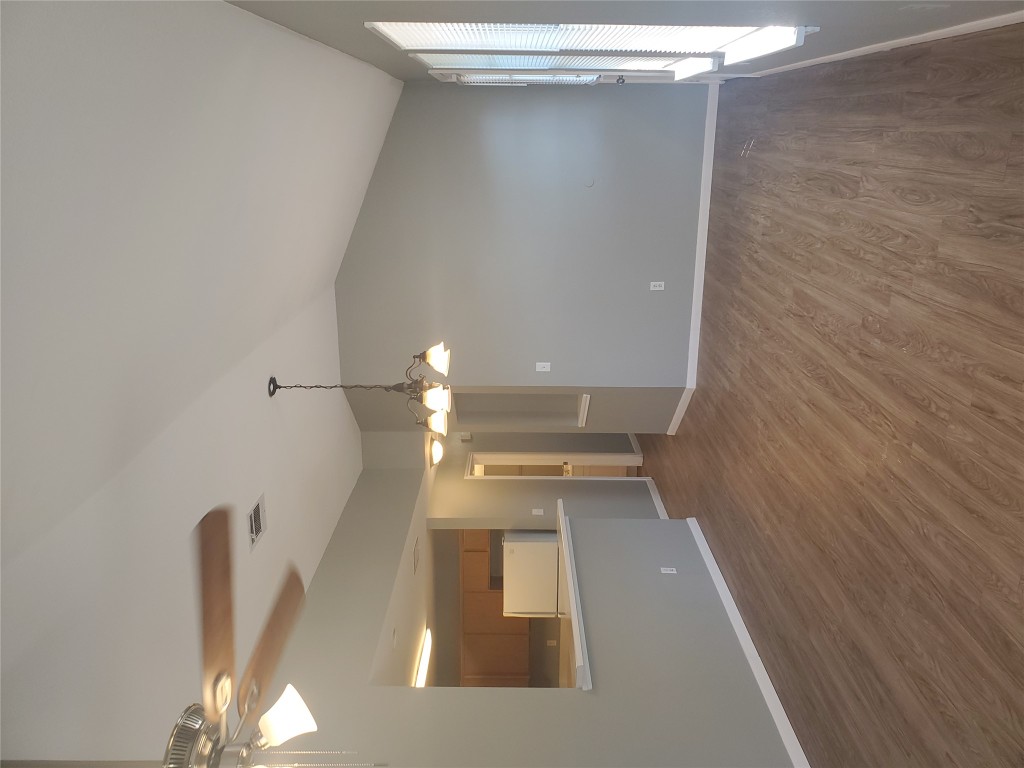 2221 Creekside Lane, Unit B Georgetown, TX 78626 - Photo 13 of 33 Unfurnished living room featuring a chandelier, dark wood finished floors, lofted ceiling, and a ceiling fan