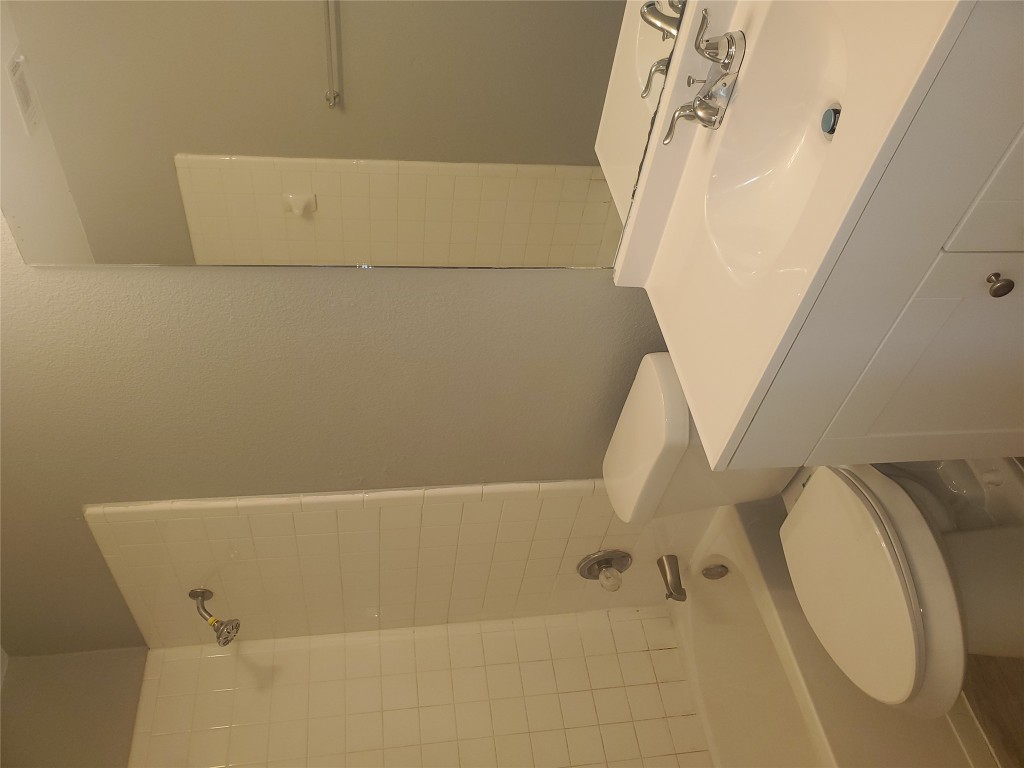 2221 Creekside Lane, Unit B Georgetown, TX 78626 - Photo 18 of 33 Full bathroom featuring washtub / shower combination, vanity, and a textured wall