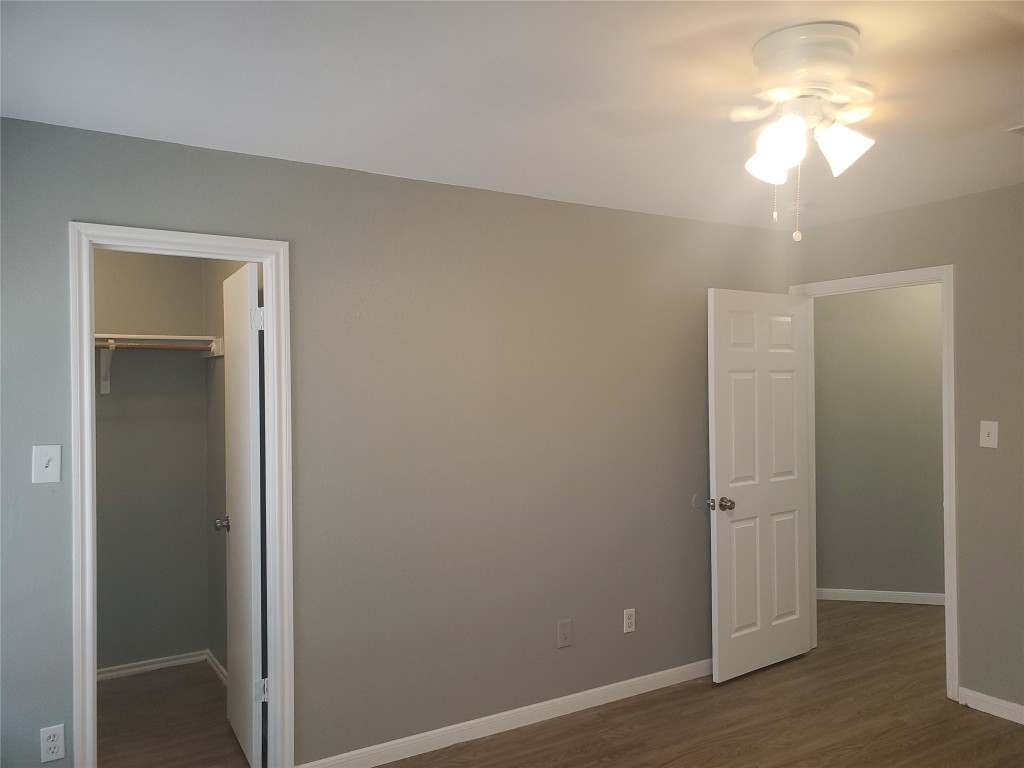 2221 Creekside Lane, Unit B Georgetown, TX 78626 - Photo 24 of 33 Unfurnished bedroom featuring dark wood-style flooring, a walk in closet, and ceiling fan