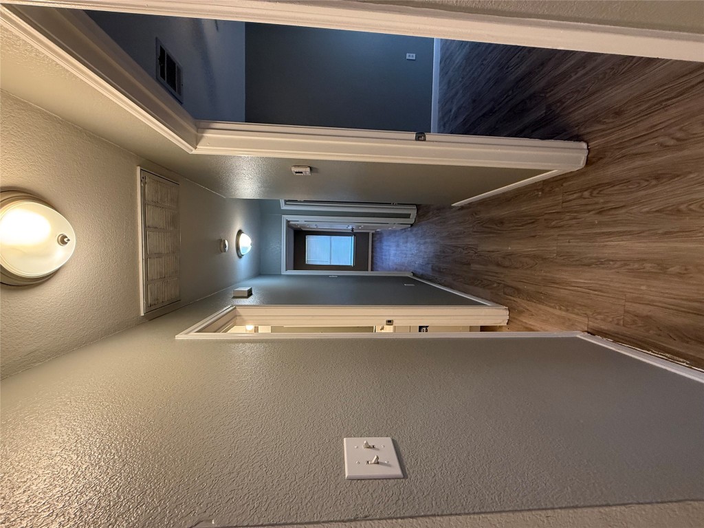 2221 Creekside Lane, Unit B Georgetown, TX 78626 - Photo 30 of 33 Hallway with dark wood-style flooring, a textured ceiling, and a textured wall