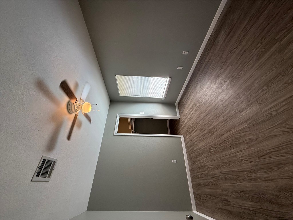 2221 Creekside Lane, Unit B Georgetown, TX 78626 - Photo 10 of 33 Unfurnished bedroom with dark wood-type flooring, a textured ceiling, a walk in closet, and a ceiling fan