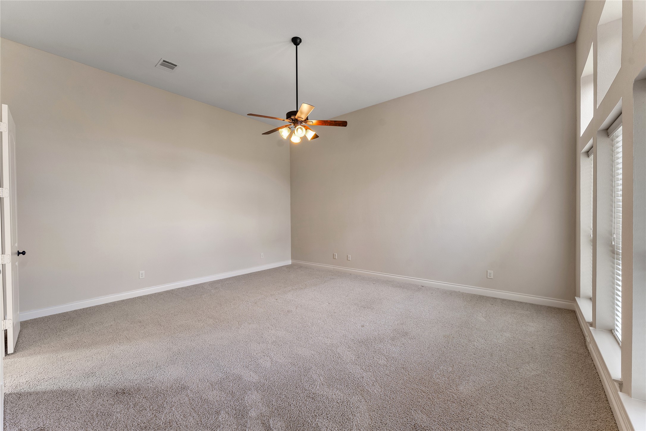 2938 Bobby Jones Road Katy, TX 77494 - Photo 15 of 28 an empty room with a chandelier fan and windows