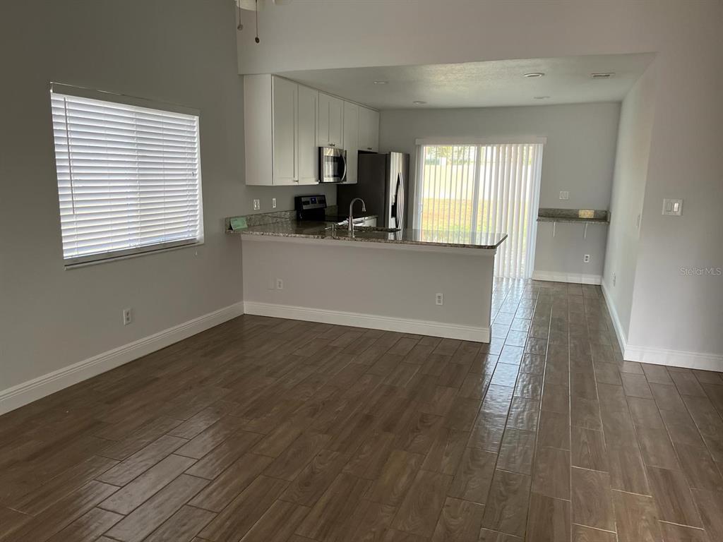 1373 Via Villanova Way Winter Springs, FL 32708 - Photo 2 of 12 a view of a kitchen with wooden floor and a window