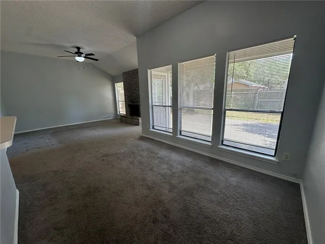 an empty room with a chandelier fan