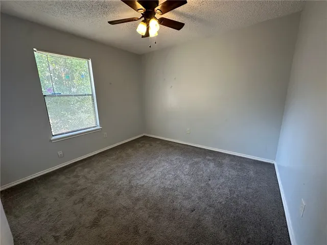 an empty room with a chandelier fan