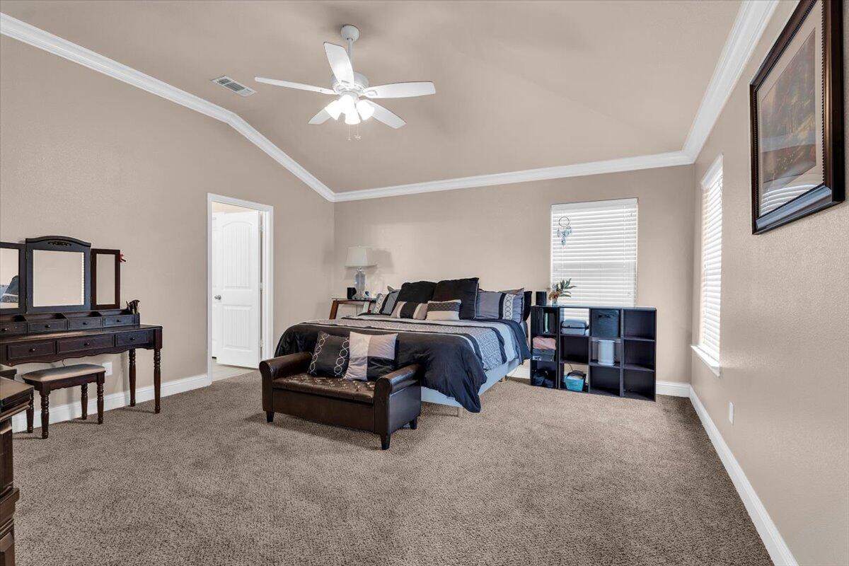 3641 Ridgely Avenue Lubbock, TX 79407 - Photo 11 of 32 a spacious bedroom with a bed and a chandelier