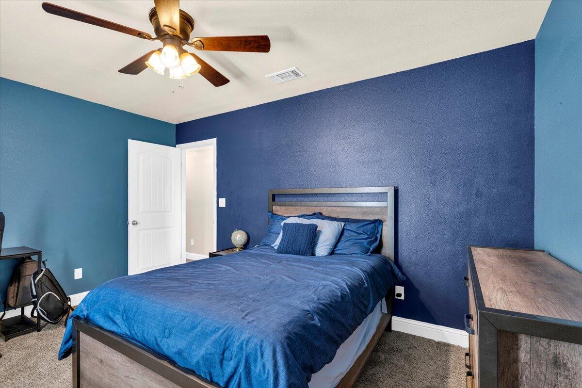 3641 Ridgely Avenue Lubbock, TX 79407 - Photo 21 of 32 a bedroom with a bed and a chandelier