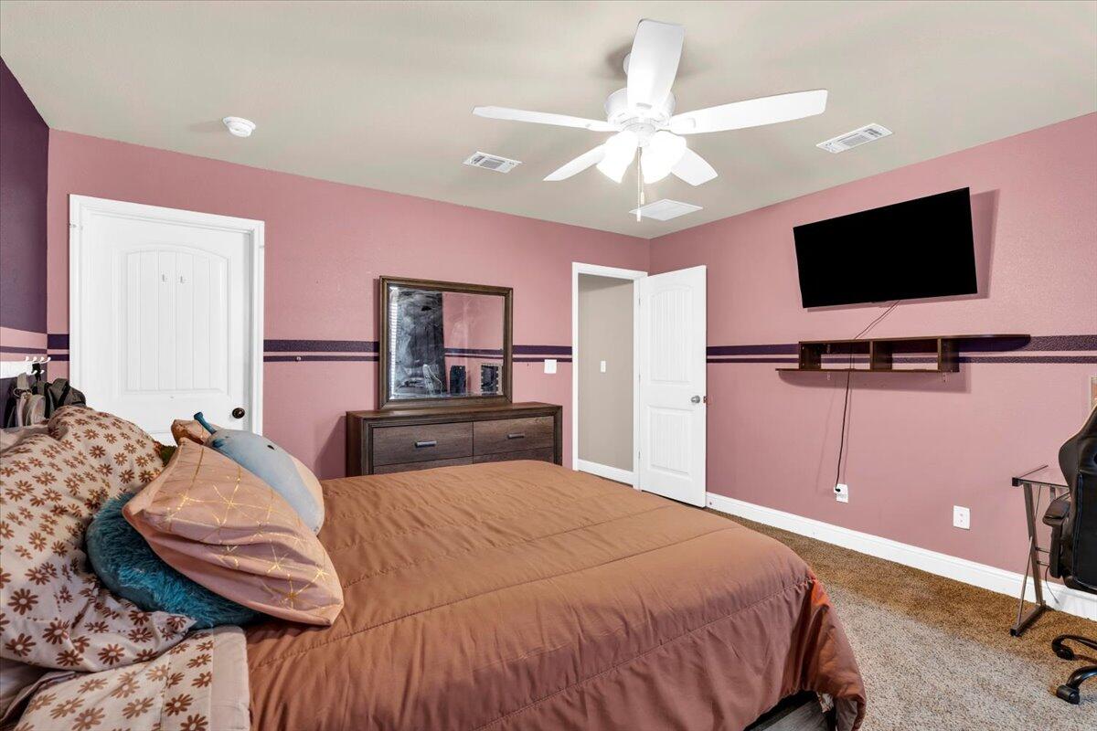 3641 Ridgely Avenue Lubbock, TX 79407 - Photo 24 of 32 a bedroom with a bed and a flat screen tv