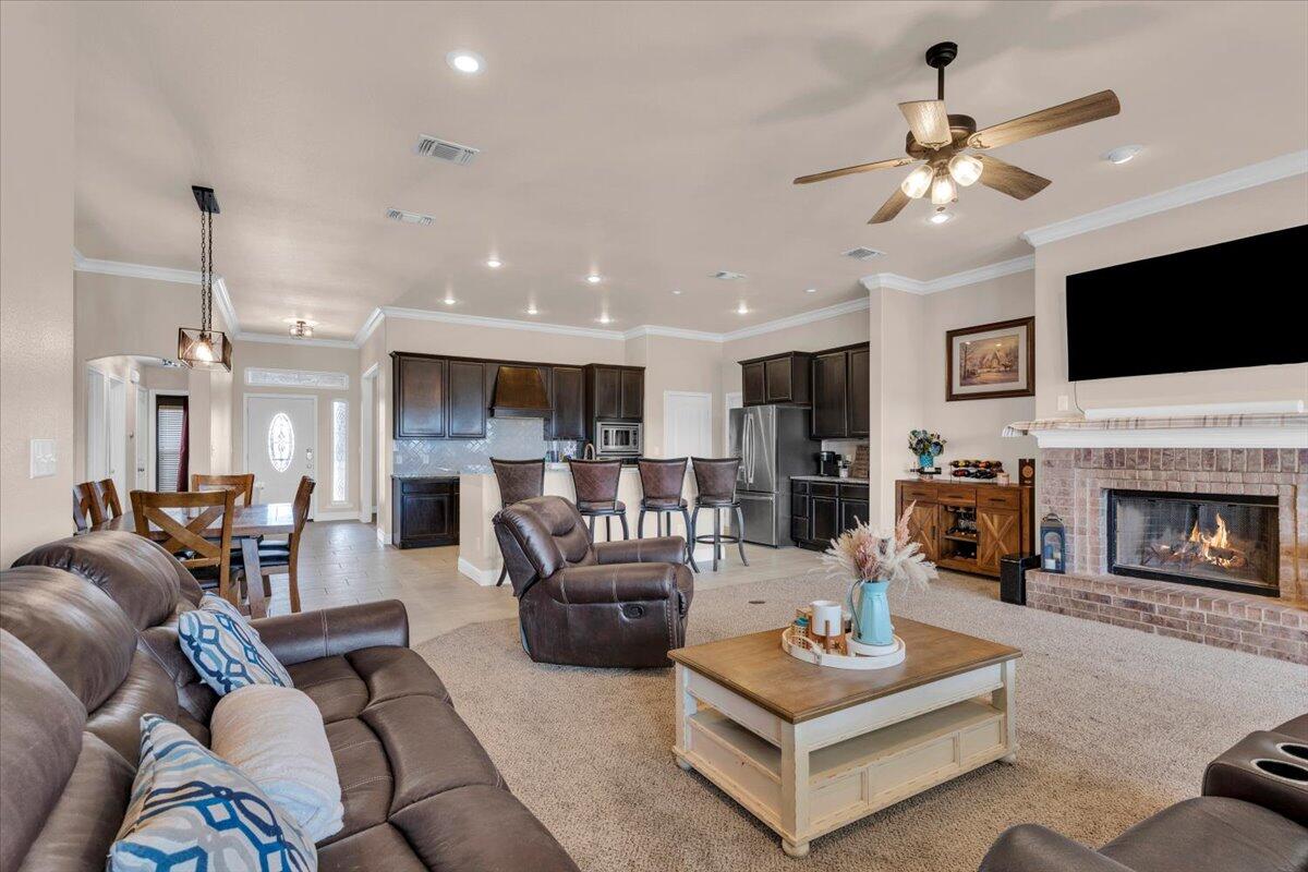 3641 Ridgely Avenue Lubbock, TX 79407 - Photo 6 of 32 a living room with furniture a fireplace and a flat screen tv