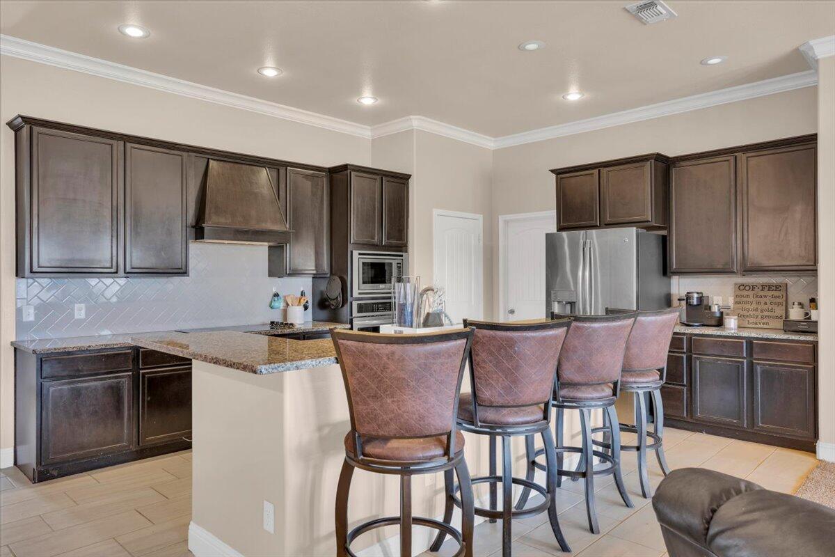 3641 Ridgely Avenue Lubbock, TX 79407 - Photo 9 of 32 a kitchen with stainless steel appliances granite countertop a stove a sink a microwave a dining table and chairs
