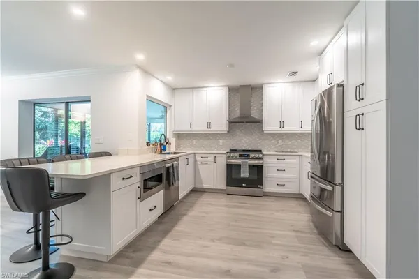 a large kitchen with stainless steel appliances a stove a sink and a refrigerator