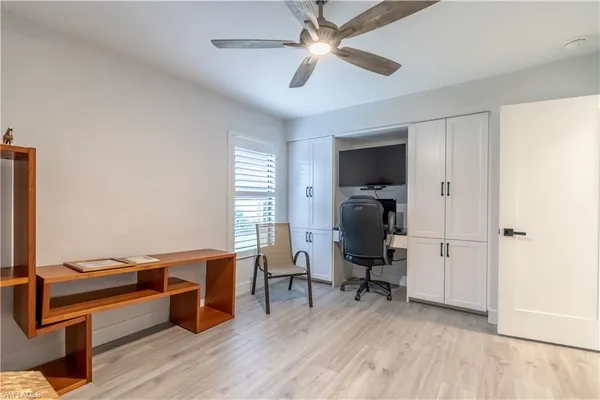 a view of a workspace with furniture and a window