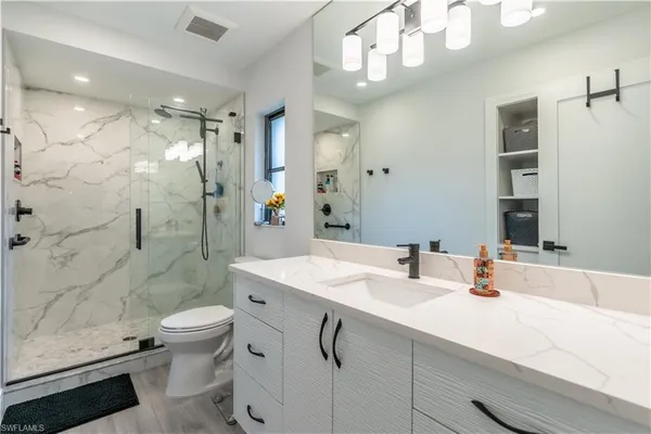 a bathroom with a sink a toilet and shower