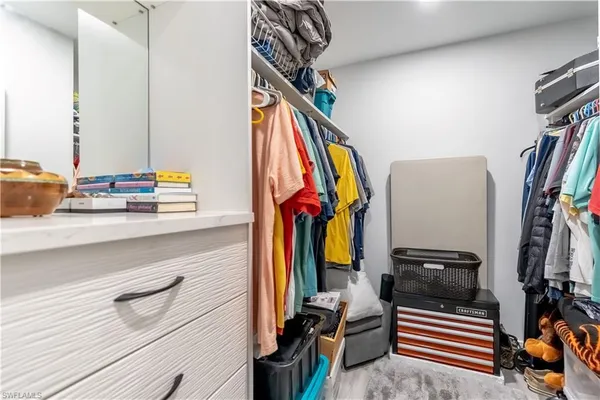 a view of walk in closet with clothes and shoes