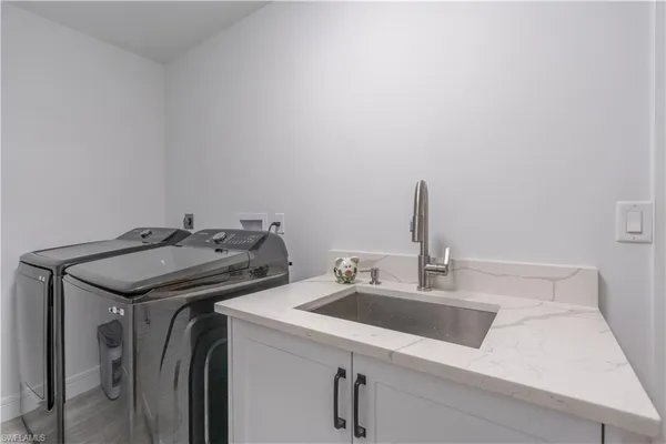 a utility room with dryer and sink