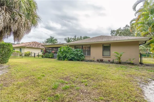 a yellow house sitting in middle of the green field