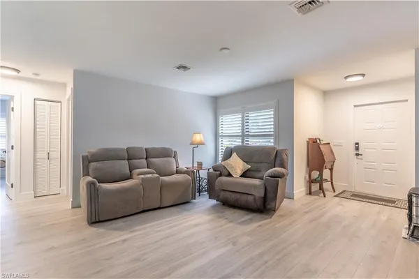 a living room with furniture and a wooden floor