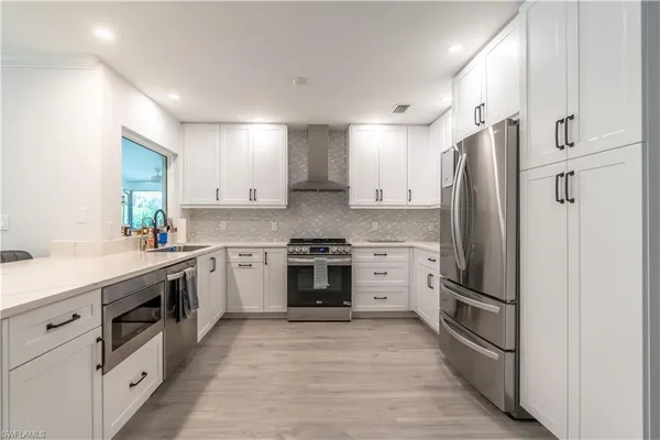 a kitchen with stainless steel appliances a refrigerator sink and cabinets