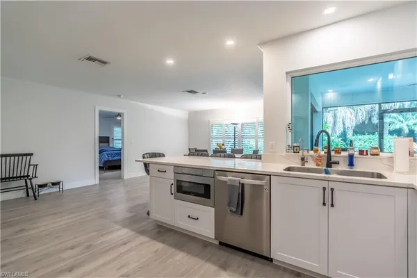 a kitchen with appliances a sink and cabinets