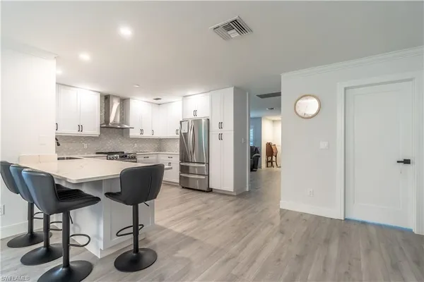 a view of kitchen with sink and refrigerator