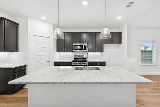 a kitchen with granite countertop a sink and refrigerator
