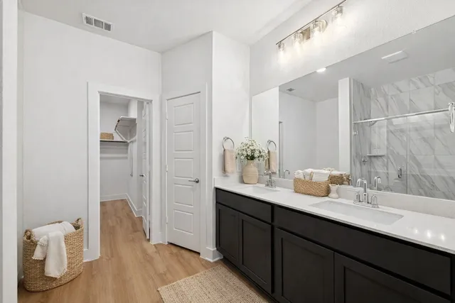a en suite bathroom with a double vanity sink and a mirror