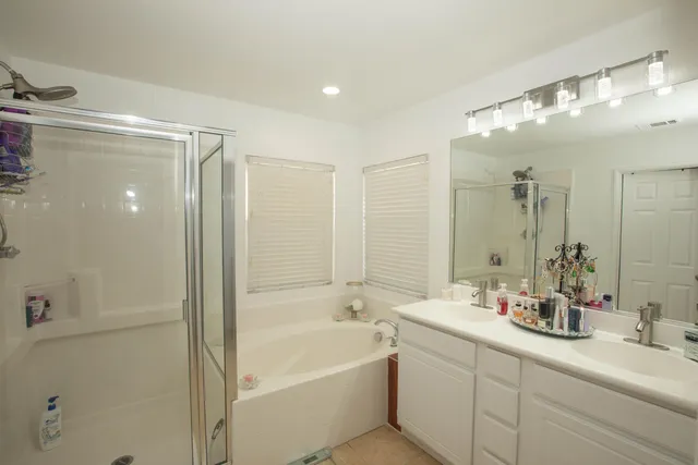 a bathroom with a tub a sink shower and mirror