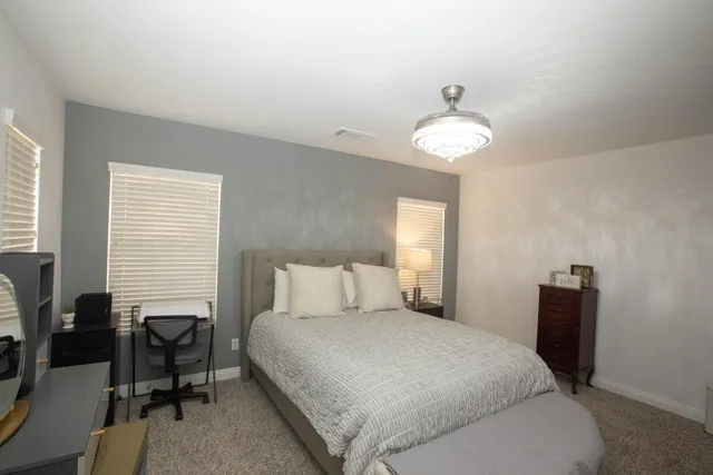 a bedroom with a bed and a chandelier