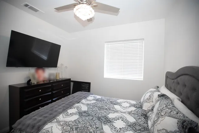 a bedroom with a bed and a flat screen tv