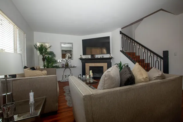 a living room with furniture a flat screen tv and a fireplace