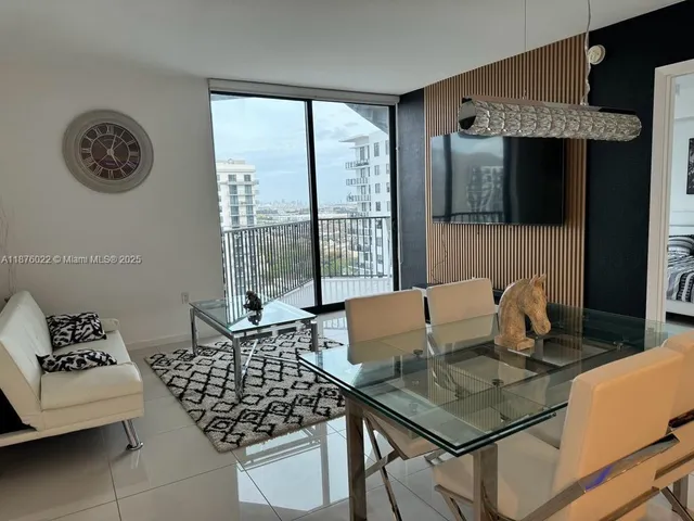a living room with furniture and a floor to ceiling window