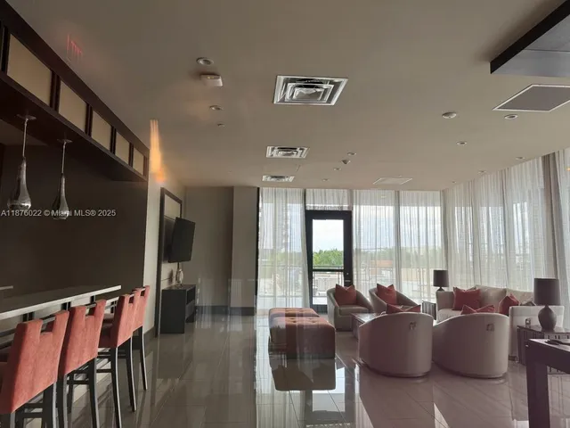 a living room with furniture and large windows