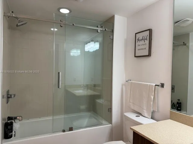 a bathroom with a shower a mirror and a sink