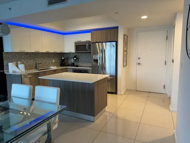 a kitchen with stainless steel appliances granite countertop a sink and a refrigerator