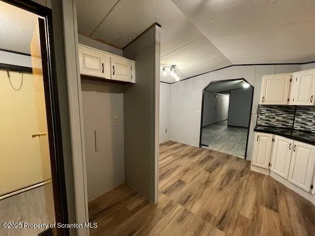 a view of a refrigerator in kitchen and an empty room