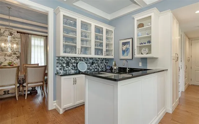 a dining room with furniture a chandelier and wooden floor