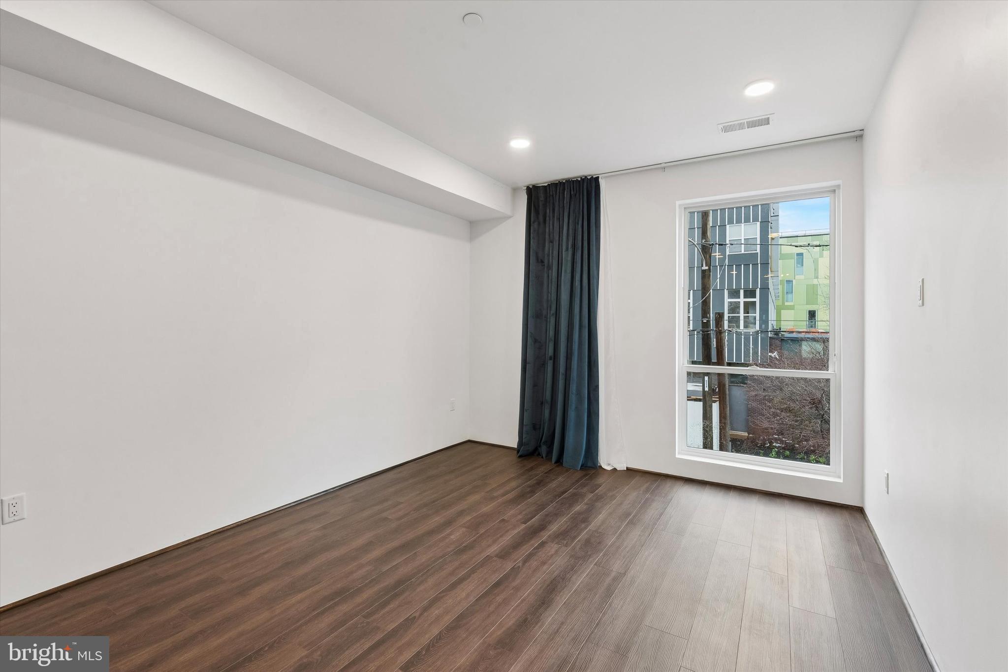 1911 North 9th Street, Unit 2 Philadelphia, PA 19122 - Photo 2 of 18 an empty room with wooden floor and windows