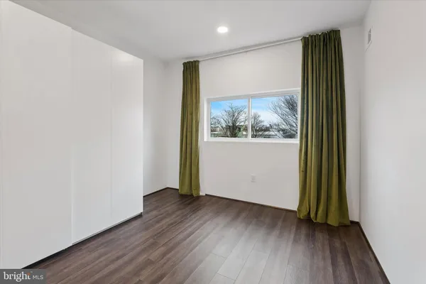 an empty room with wooden floor and a window