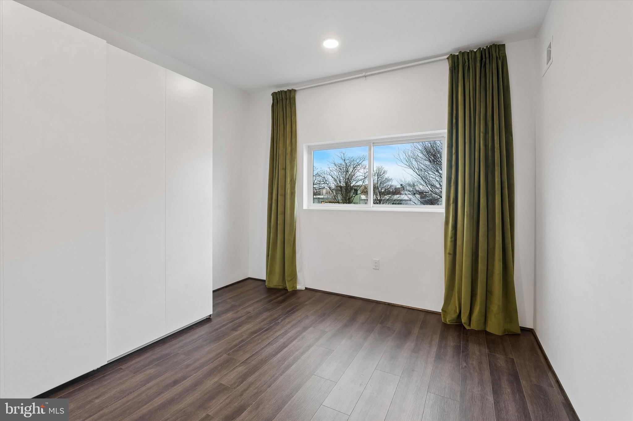 1911 North 9th Street, Unit 2 Philadelphia, PA 19122 - Photo 7 of 18 an empty room with wooden floor and a window