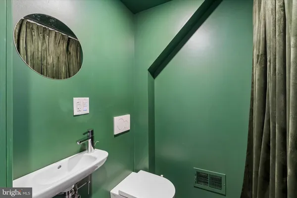 a bathroom with a toilet a sink and mirror