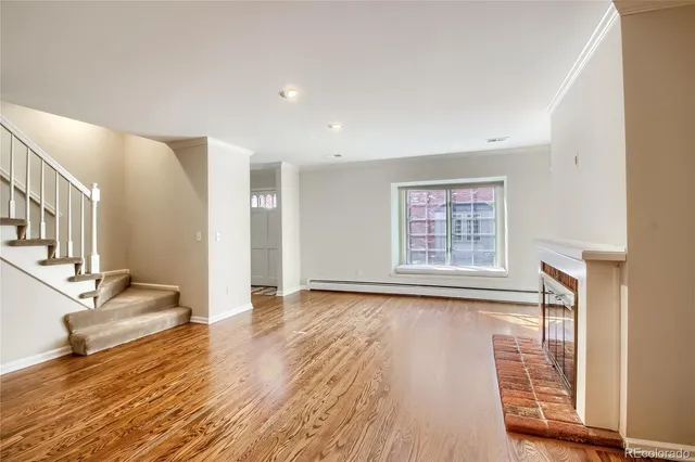 a view of an empty room with a fireplace and a window