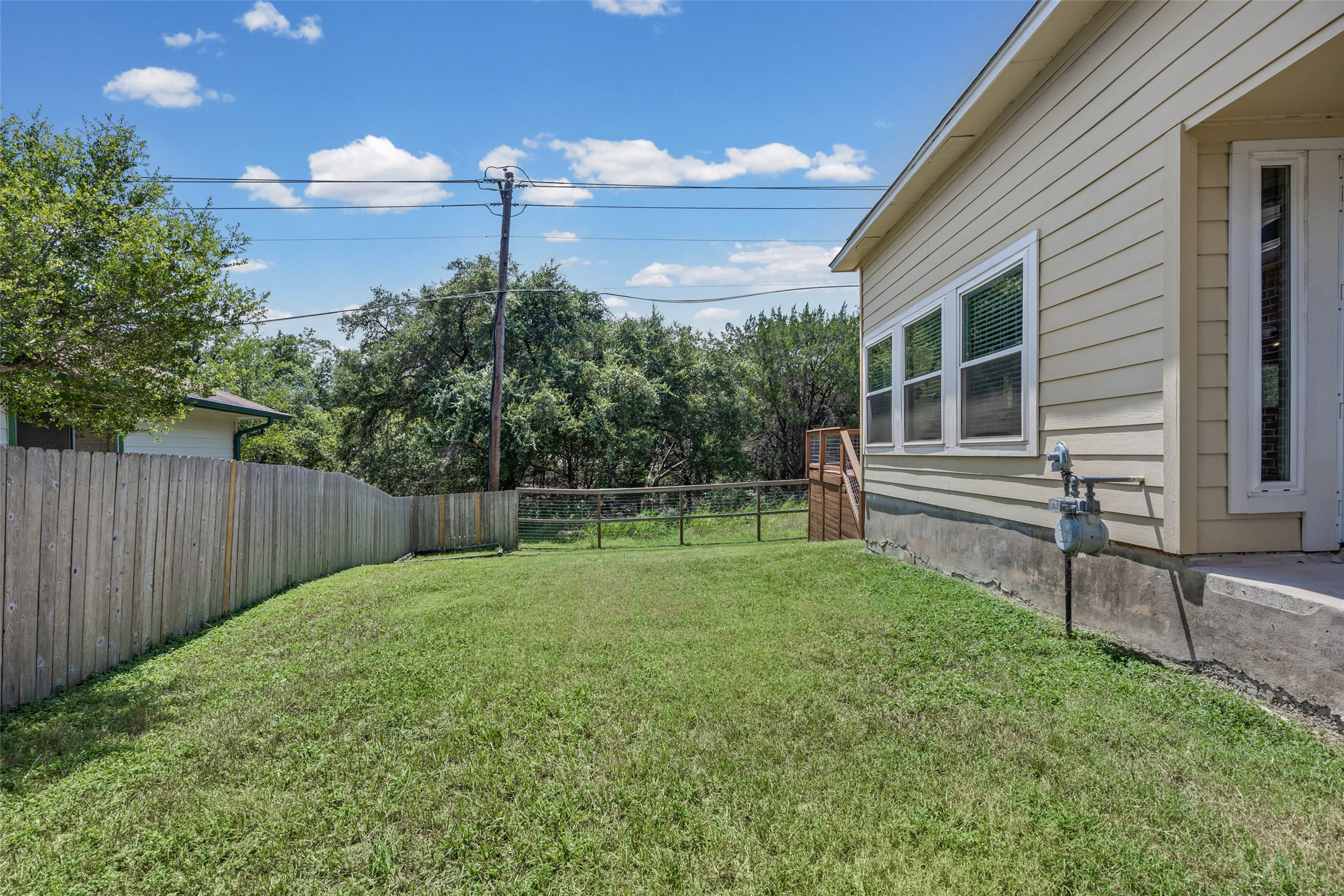 3011 Wadsworth Way Austin, TX 78748 - Photo 31 of 35 A fully fenced backyard with ample green space and a serene natural backdrop.