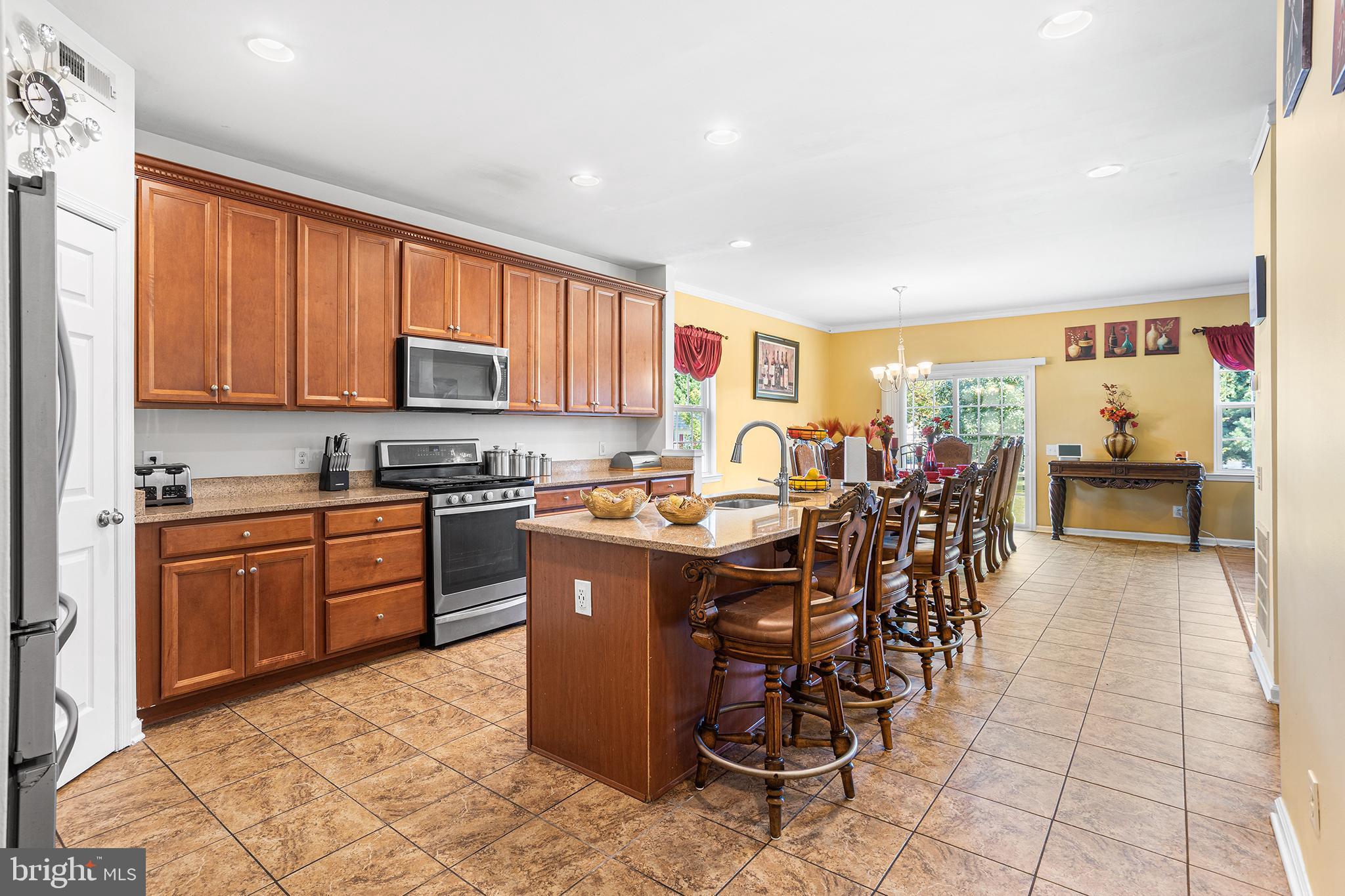 323 Pigott Drive Florence, NJ 08518 - Photo 7 of 36 a kitchen with stainless steel appliances kitchen island granite countertop a stove a sink a dining table and chairs