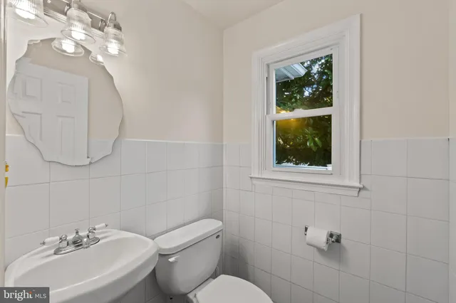 a bathroom with a toilet a sink and mirror