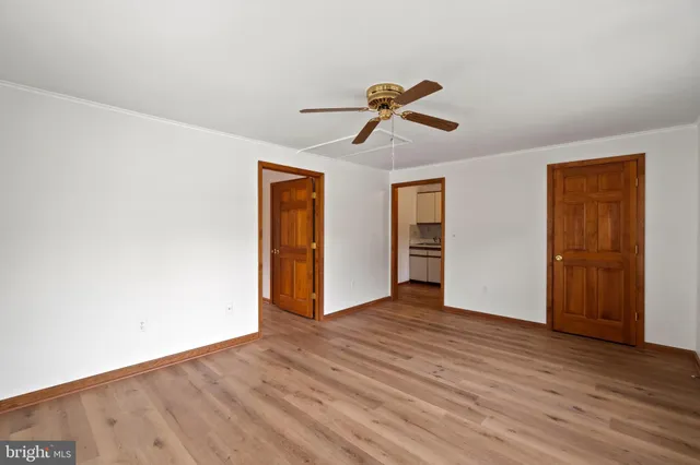 a view of room with wooden floor and ceiling fan