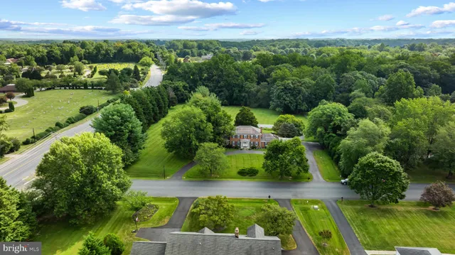 an aerial view of residential houses with outdoor space and trees all around