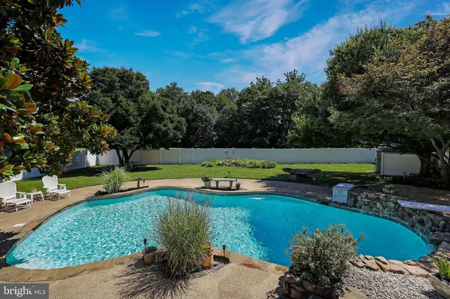 a view of a swimming pool with a yard and outdoor seating