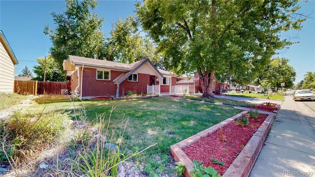 a view of backyard of house with wooden fence and large trees