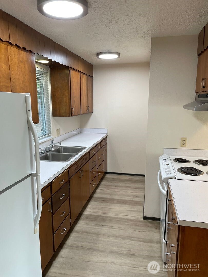 13317 28th Street Northeast, Unit A/B Lake Stevens, WA 98258 - Photo 2 of 14 a kitchen with stainless steel appliances granite countertop a sink stove and refrigerator